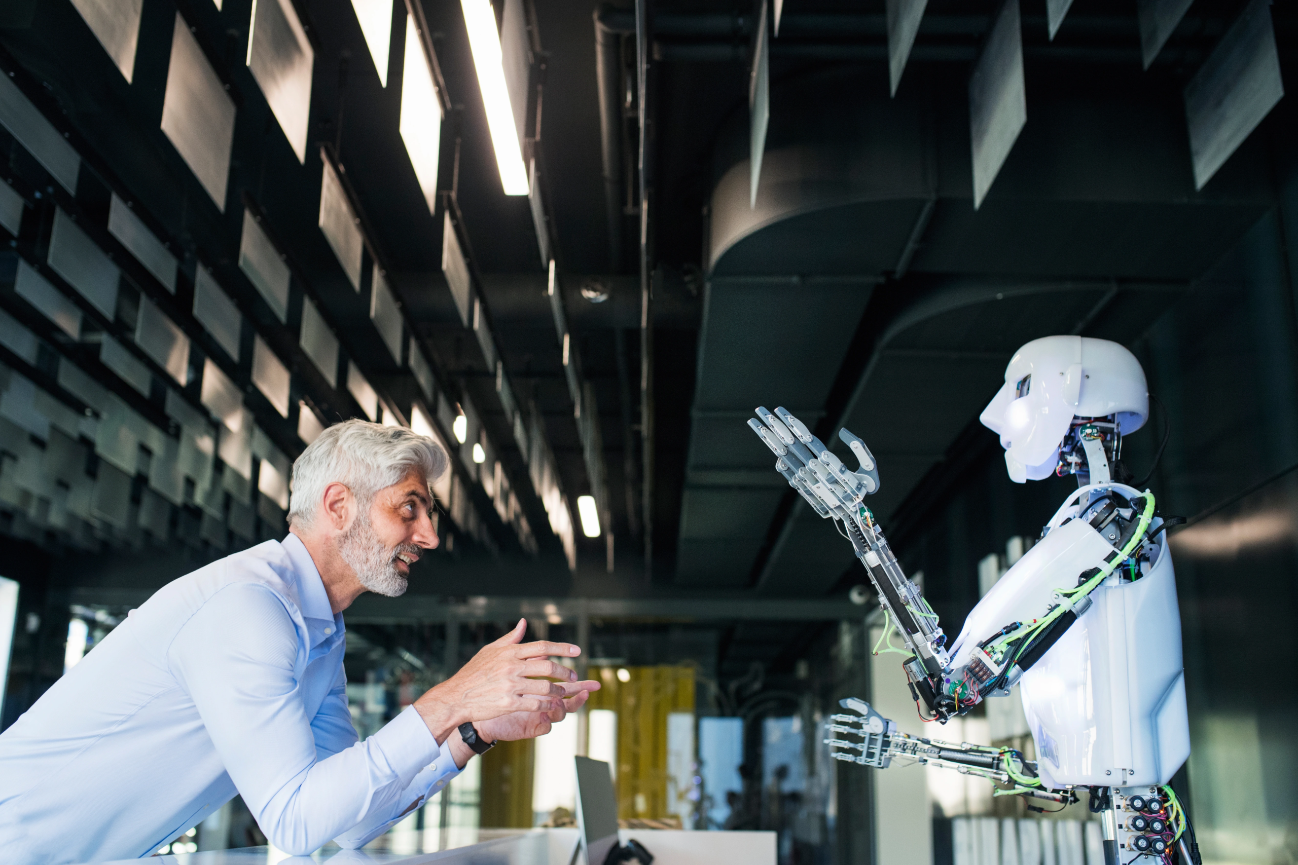 A business professional and a humanoid robot collaborating in a modern office, symbolizing the balance between human expertise and AI automation in data labeling.